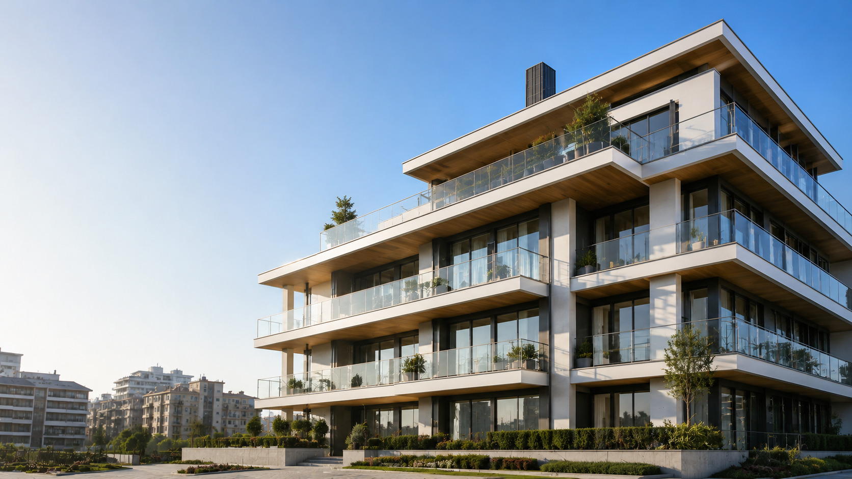 Edificio residenziale moderno ultimato con facciata bianca e ampi balconi in vetro.